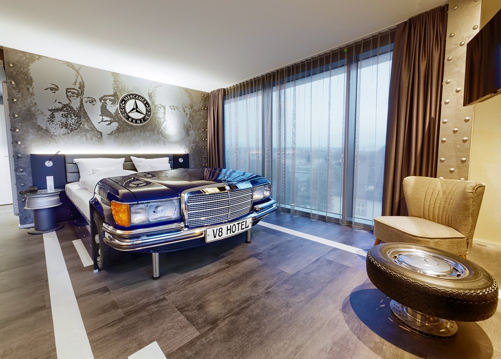 Themenzimmer im V8 Hotel mit Bett in einer Mercedes-Karosserie
